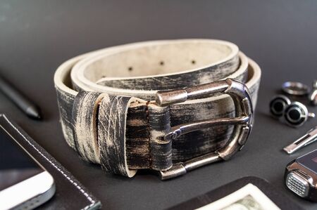 Genuine leather belt close up on black background. An element of modern clothing styleの写真素材