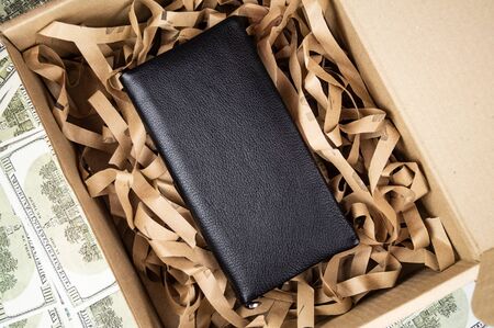 wallet made of genuine leather on the table in the process of packing a gift