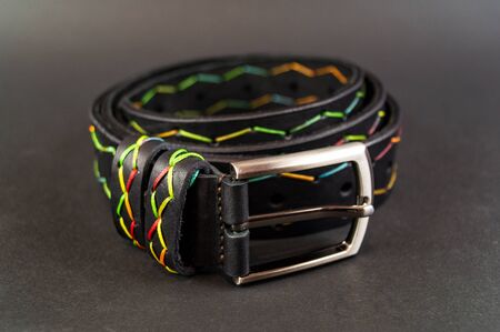 Genuine leather belt close up on black background. An element of modern clothing styleの写真素材