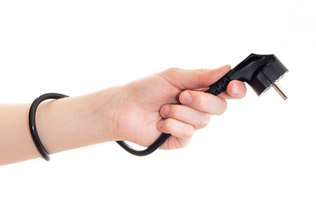 The concept girl holds a power cable plug in her hand. Image on a white backgroundの写真素材