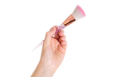 Makeup brush in a girl's hand on a white background. image isolateの写真素材