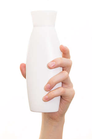The girl holds a jar of shampoo in her hands. Image on a white backgroundの写真素材