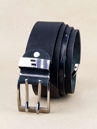 A leather belt with a clasp lies neatly on the table. background light paperの写真素材