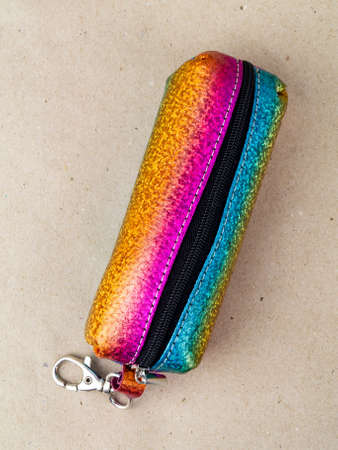 A beautiful and stylish key holder lies on a paper background. close-up photo