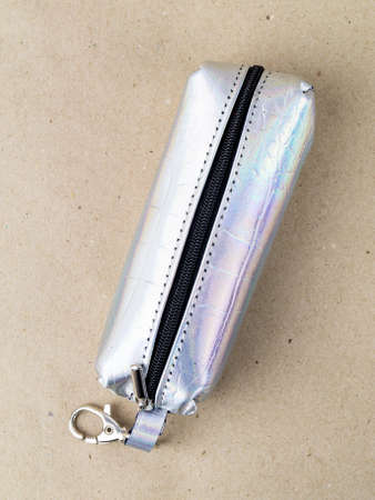 A beautiful and stylish key holder lies on a paper background. close-up photo