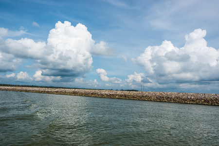Dam rock on the sea with blue sky and cloudsの写真素材