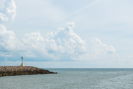 Dam rock on the sea with blue sky and cloudsの写真素材
