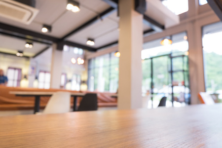 Wooden table in modern loft cafe. Abstract blurred restaurant backgroung with bokeh