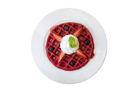 Red belgium waffle topped with fresh strawberry blueberry and whipped cream isolated on white backgroundの写真素材