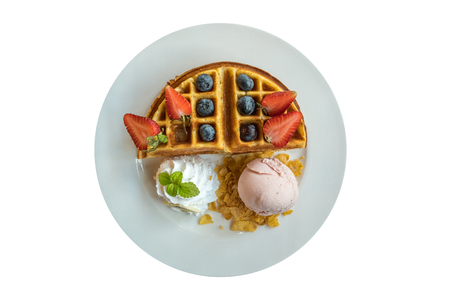 Plate of belgium waffle with strawberry ice cream and fresh berry isolated on white backgroundの写真素材