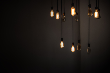 Idea concept with good and broken light bulbs hanging from ceilingの写真素材