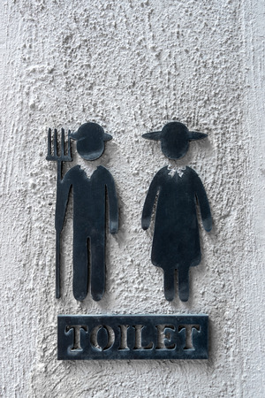 Close up vintage toilet sign on raw concrete wall backgroundの写真素材