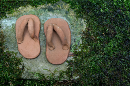 Sculpture of sandal made from baked clay in the garden