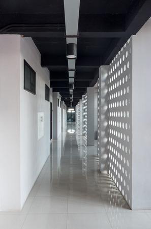 Long modern hotel corridor with sunlight through the wall. Raw concrete entrance hall in loft styleのeditorial素材
