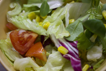Fresh colourful mixed leaves salad with cherry tomatoes and corn in a bowl.の写真素材