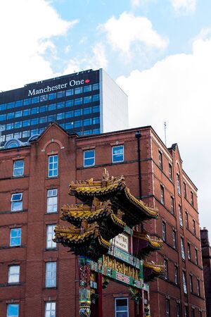 MANCHESTER, UNITED KINGDOM - 5 March, 2016: A view of the Manchester One building with Chinatown ornamental archway on Faulkner Street in the foreground.のeditorial素材
