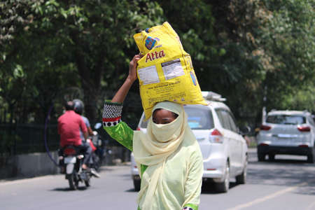 Dehradun, Uttarakhand/India- August 02 2020: Poor Indian people doing work by wearing masks, because...