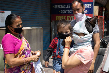 Dehradun, Uttarakhand/India - September 06 2020: lady covering her face with her child.のeditorial素材