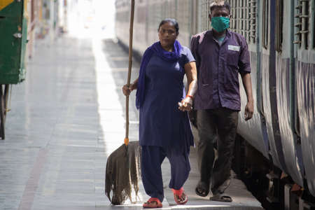 Dehradun, Uttarakhand/India-September 12 2020: Cleaning staff at the railway station wearing face...