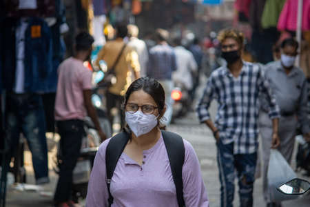Dehradun, Uttarakhand/India-October 14 2020:A girl student wearing face mask is passing through the market in India, the government in India has made the mask mandatory due to the corona epidemic.のeditorial素材