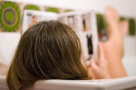 Woman reading and relaxing in the tub. Shallow depth of field.の写真素材