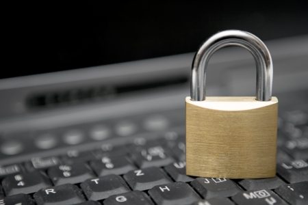 Padlock standing on a black laptop keyboard.