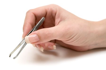 Woman holding a pair of tweezers. White background.の写真素材