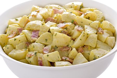 Delicious isolated dish of potato salad, with cooked chopped bacon and parsleyの写真素材