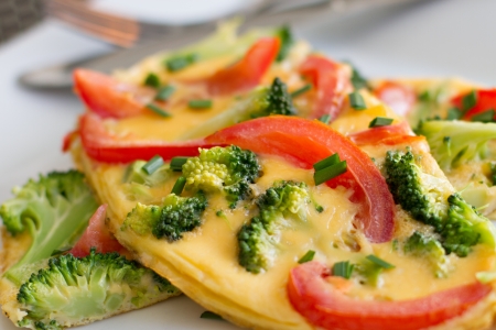Close up of healthy tomato and broccoli omlette garnished with chives.
