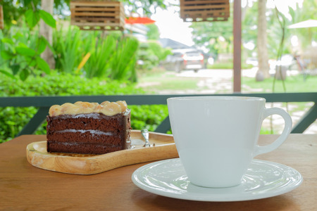 A cup of coffee and cake on the wood table.の写真素材