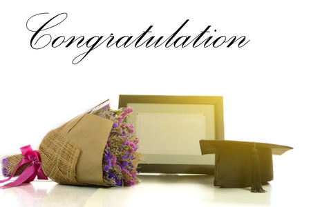Graduation cap certificate and a bouquet of flowers for graduation in a warm light on a white background.の写真素材