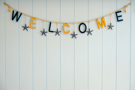 Alphabet of welcome hung on the wooden wall.の写真素材