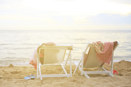 Two beach chairs on the beach near sea on the warm light.の写真素材