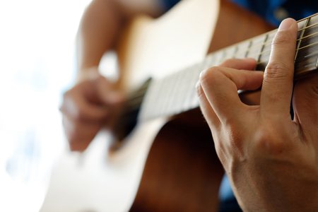 Closeup hand of someone playing guitar.