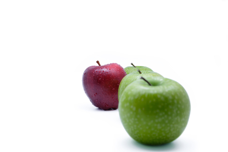 Red apple outside green apples line on white background with copy space.の写真素材