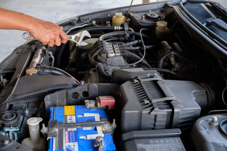 Someone hold wrench for fix a car.