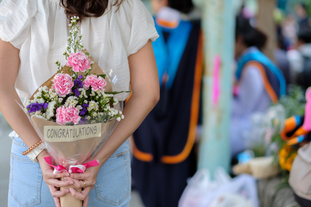 Woman hide bouquet for surprise someone.の写真素材