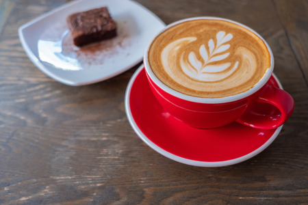 Close up of a cup of coffee and cake on the wood table.の写真素材