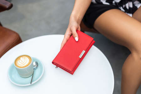 Wallet on the white table and a cup of coffeeの写真素材