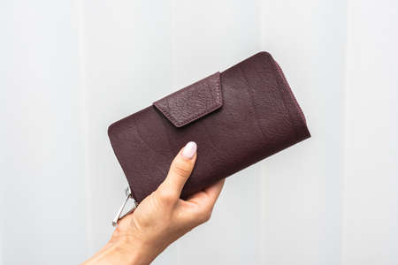 Wallet in hand on wall white backgroundの写真素材