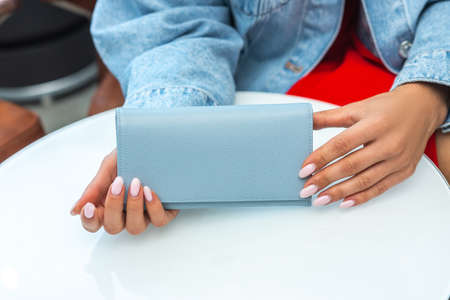 A purse on a white table in the hands of a ladyの写真素材