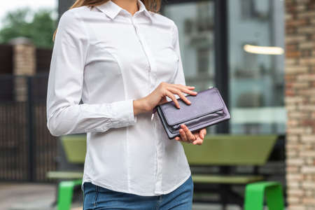 Girl in white holds a purse in her handの写真素材