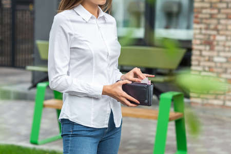 Girl in white holds an open wallet in her handの写真素材