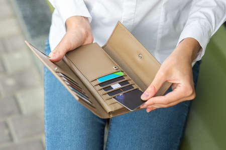 A girl holding an open wallet in her handの写真素材