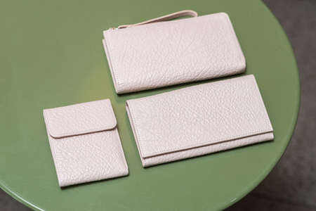 Three white wallets on the green tableの写真素材