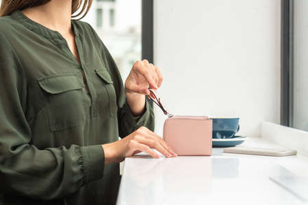 Girl holding a beautiful wallet on tableの写真素材