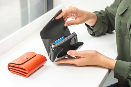 Open wallet in the girls hands on tableの写真素材