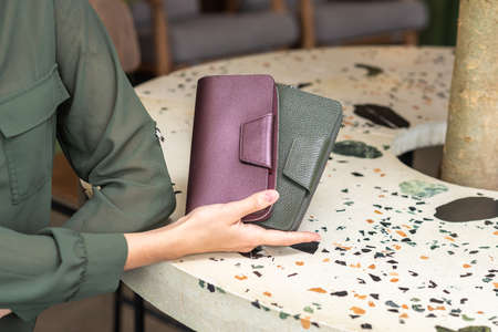 Two wallets in the lady hand on the tableの写真素材