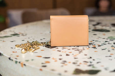 Beautiful leather wallet with gold chain on the tableの写真素材