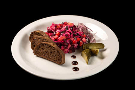 Beautiful dishes vinaigrette with bread in a white plateの写真素材